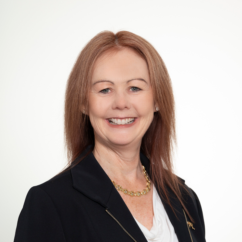 Headshot of Horse Committee Chair Denise Ovens, smiling and wearing a black blazer and white blouse with a gold necklace.