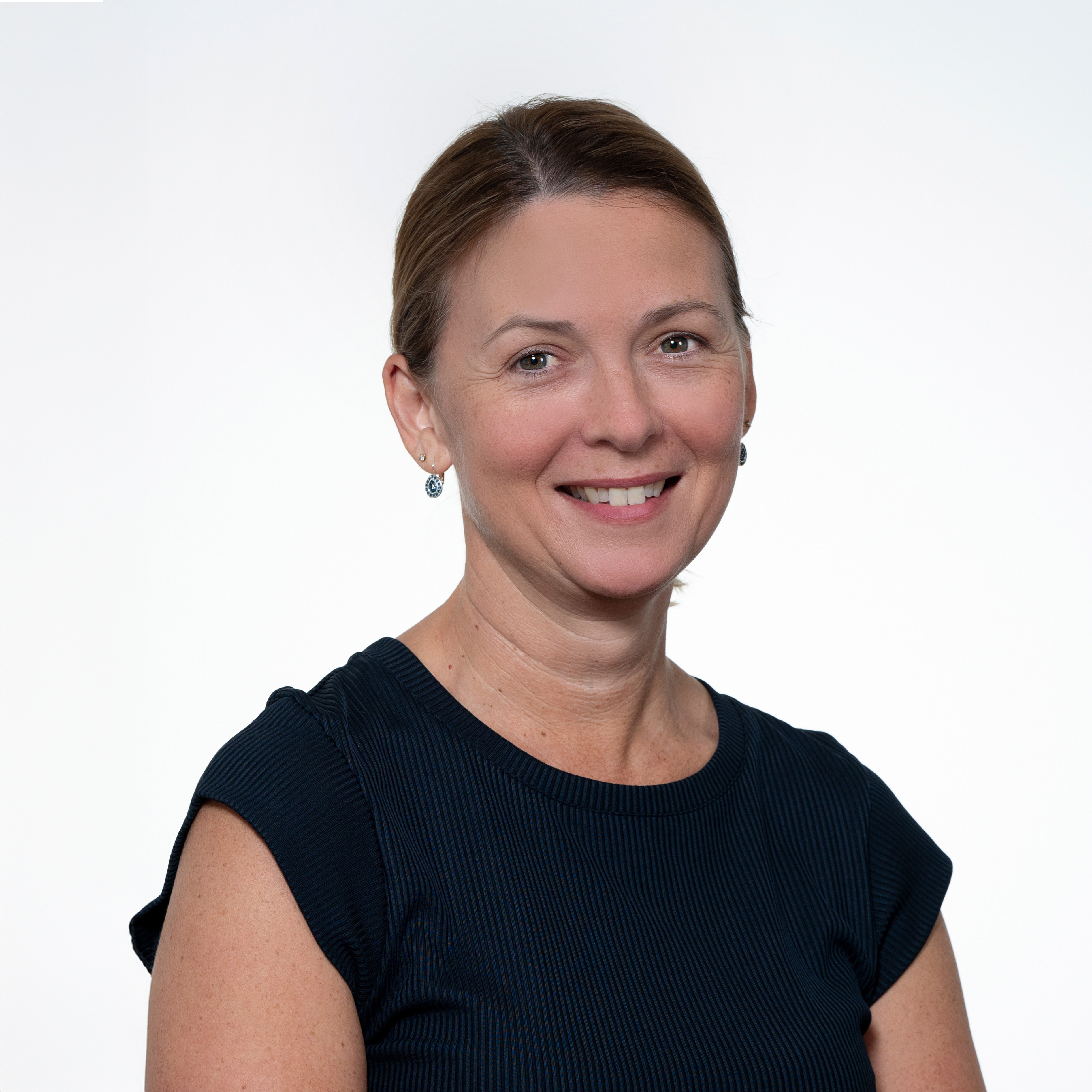 Headshot of RAS President &  Chief Executive Assistant Alexis Gachon, smiling and wearing a dark top and earrings.