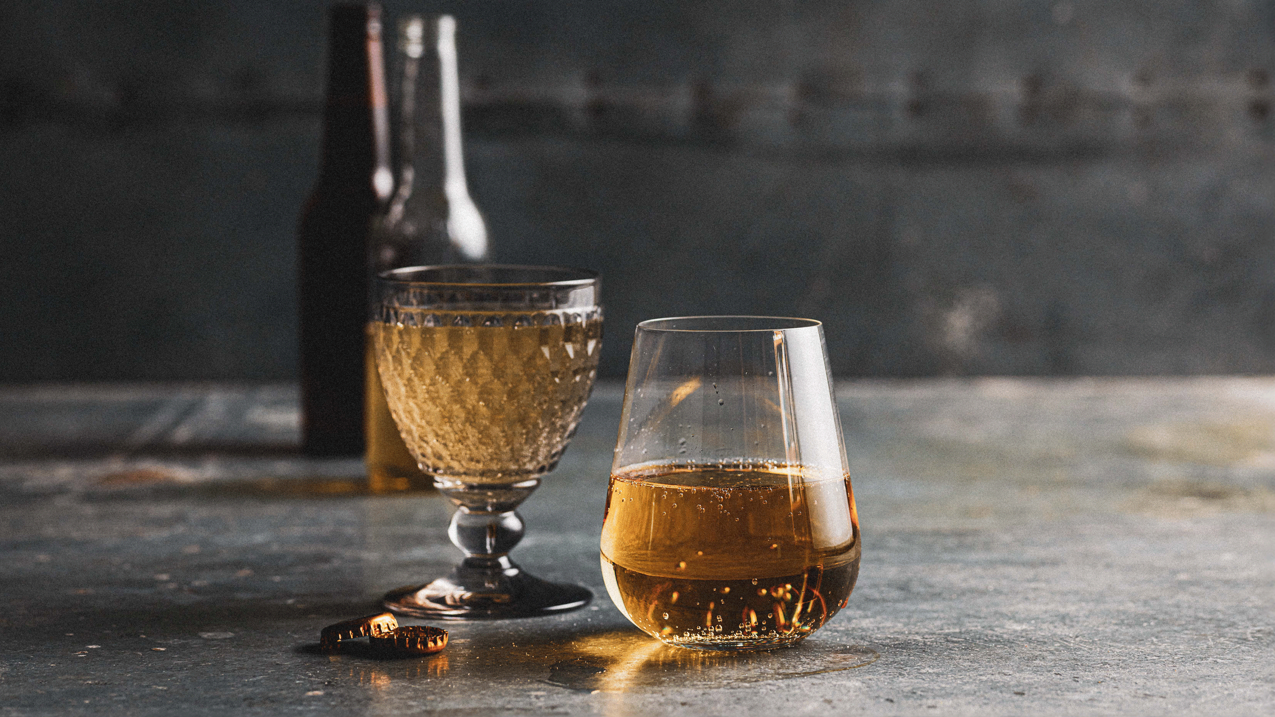 Glasses of golden beer and cider with bottles in the background for the Sydney Royal Beer & Cider Show.