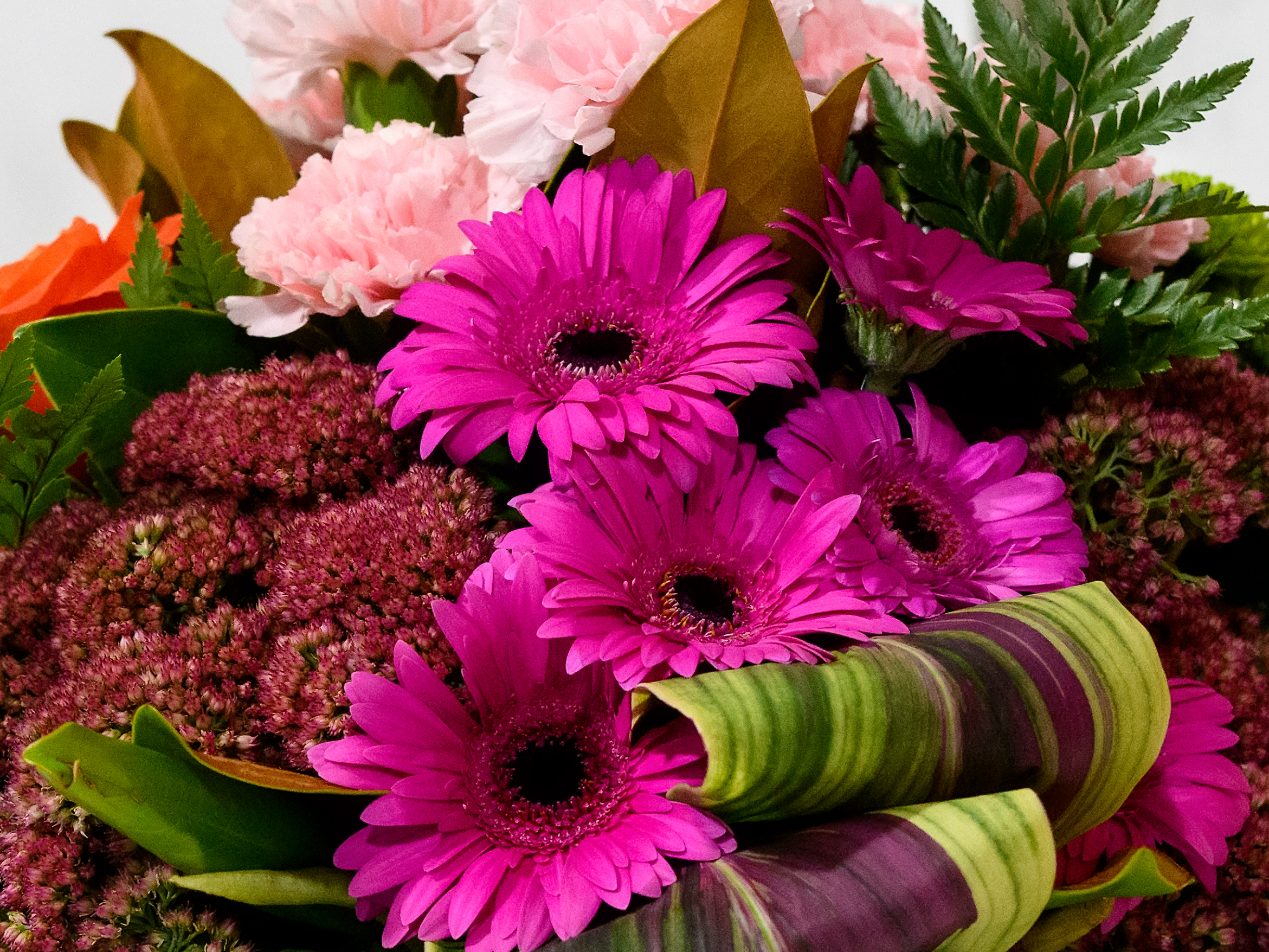 A bouquet arrangement of bright pink and purple flowers with green foliage at the Sydney Royal Flower & Garden Show.