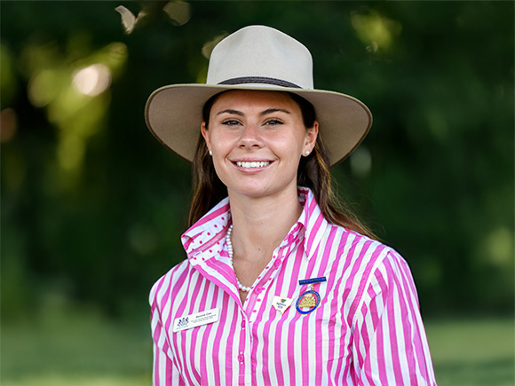Headshot of 2025 finalist Bonnie Cox, a woman with long brown hair, hat and striped shirt, smiling.