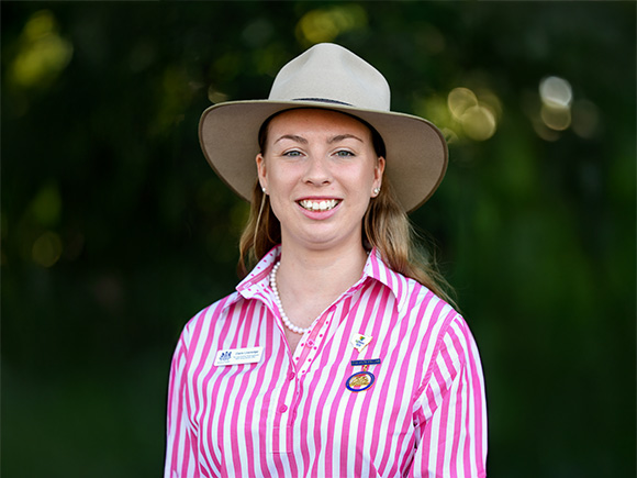 Headshot of 2025 Claire Liversidge, a woman with light brown hair, wearing pearl earrings and a wide-brimmed hat.