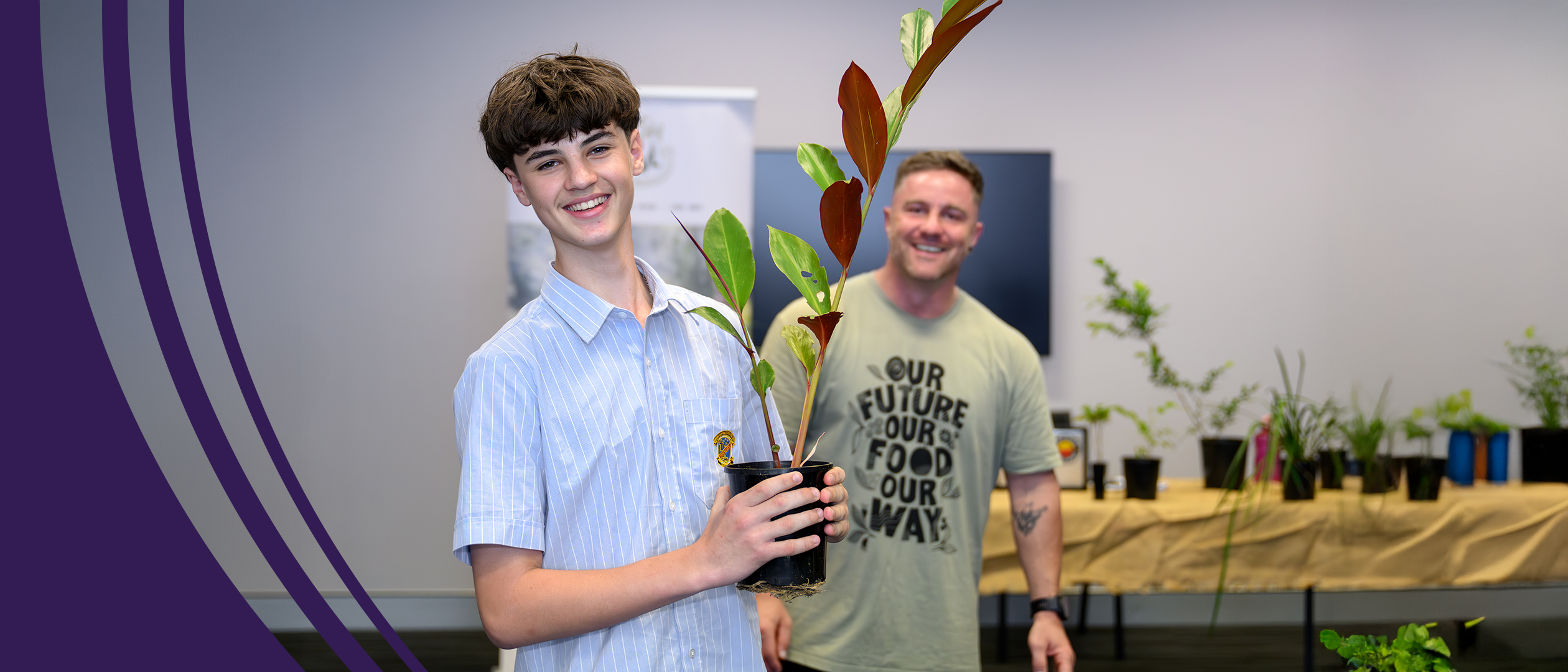 Smiling student holding a potted plant with a mentor standing behind, promoting agricultural education.